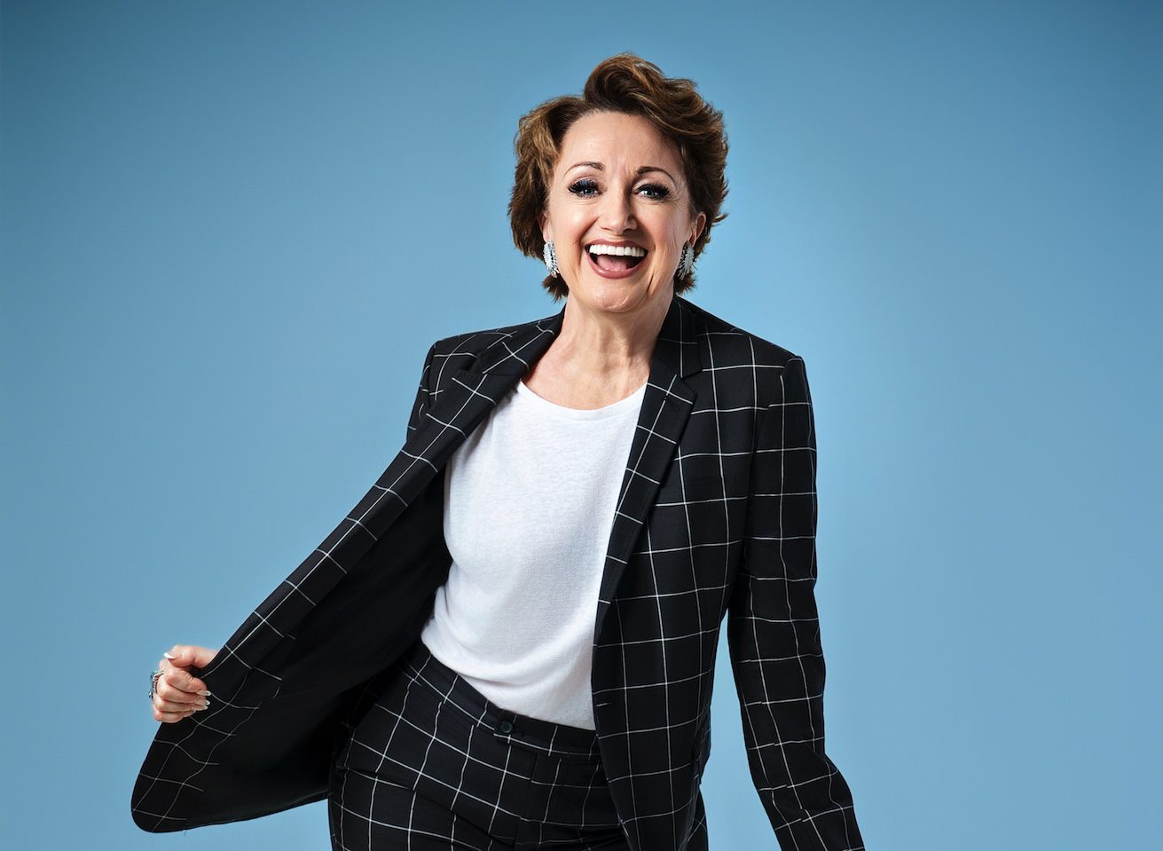 Caroline O'Connor wearing black jacket and white t-shirt, smiling